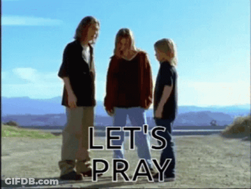 A Group Of People Standing On A Dirt Road With The Words Let 'S Pray GIF