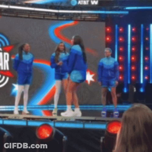 A Group Of People Standing On A Stage In Front Of A Screen That Says At & T GIF