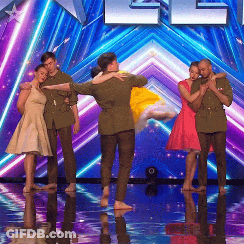 A Group Of People Standing On A Stage In Front Of A Sign That Says ' America ' On It GIF