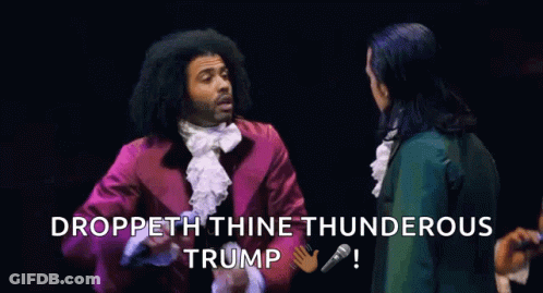 A Group Of People Standing On A Stage With A Microphone In Front Of Them And The Words Droppeth Thine Thunderous Trump . GIF