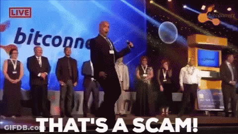 A Group Of People Standing On A Stage With The Words That 'S A Scam On The Screen Behind Them GIF
