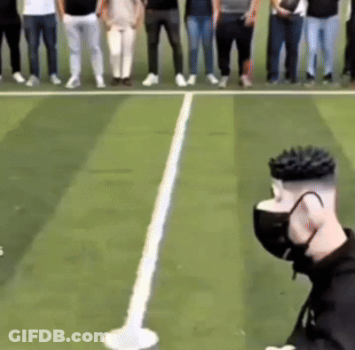 A Group Of People Standing On A Tennis Court With A Person Wearing A Mask GIF