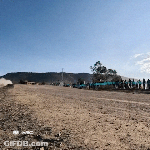 A Group Of People Standing On The Side Of A Dirt Road With The Word Fia On The Bottom Right GIF
