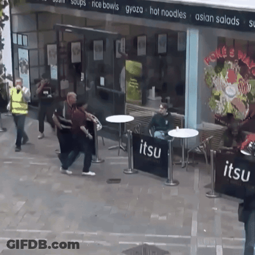 A Group Of People Standing Outside Of A Restaurant Called Jitsu GIF