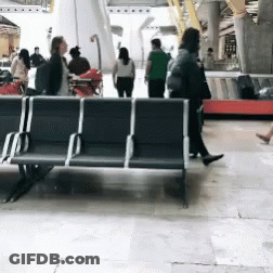A Group Of People Walking Around A Waiting Area GIF