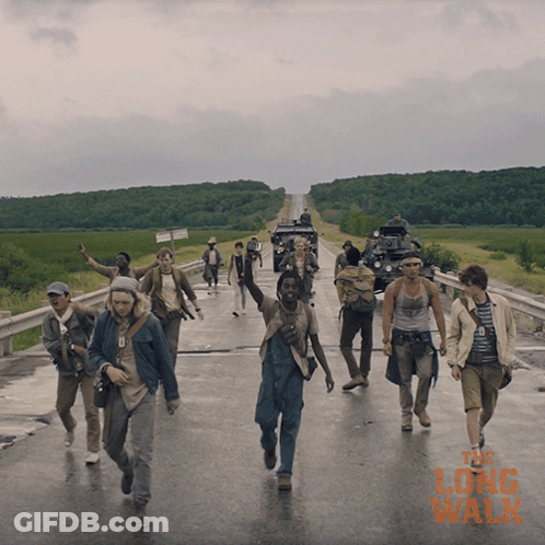 A Group Of People Walking Down A Road With The Long Walk Written On The Bottom Right GIF