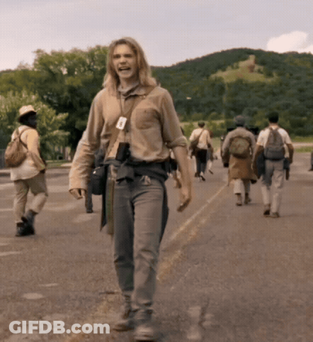 A Group Of People Walking Down A Street With A Man Wearing A Name Tag That Says A On It GIF
