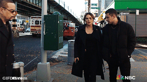 A Group Of People Walking Down A Street With A Nbc Logo On The Bottom GIF