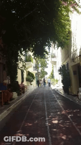 A Group Of People Walking Down A Street With A Sign That Says ' A ' On It GIF