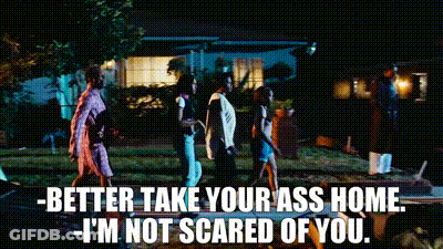 A Group Of People Walking In Front Of A House At Night With The Words Better Take Your Ass Home I 'M Not Scared Of You GIF