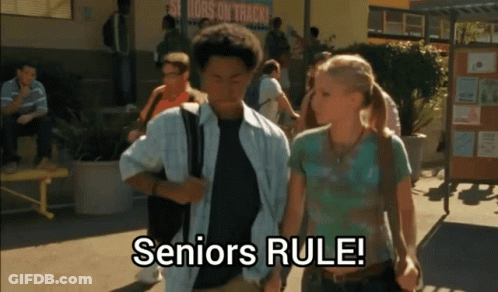 A Group Of People Walking In Front Of A Sign That Says " Seniors Rule " GIF