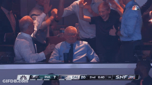 A Group Of People Watching A Game With A Scoreboard That Says Phil 7 Dal 20 GIF