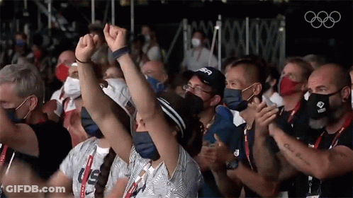 A Group Of People Wearing Face Masks Are Applauding While Wearing Us Shirts GIF