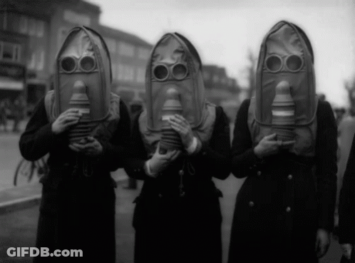 A Group Of People Wearing Gas Masks Are Standing In A Line GIF