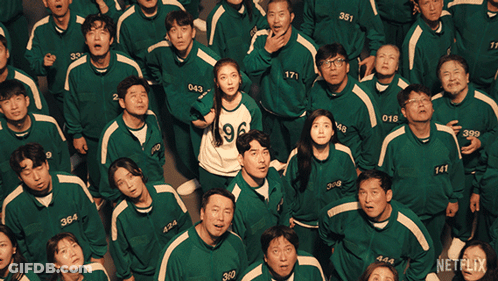 A Group Of People Wearing Green Uniforms With Numbers On Them Are Looking Up GIF