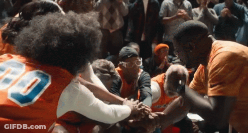 A Group Of People Wearing Orange Jerseys With The Number 80 On Them GIF