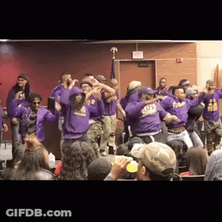A Group Of People Wearing Purple Shirts With The Word Squad On Them Are Dancing In A Room GIF