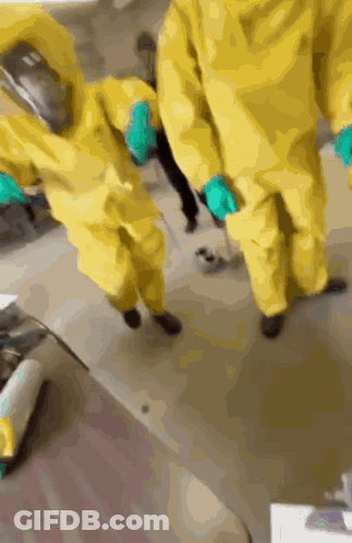 A Group Of People Wearing Yellow Suits And Gloves GIF