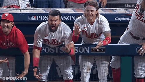 A Group Of Philadelphia Phillies Baseball Players Standing Behind A Dugout GIF