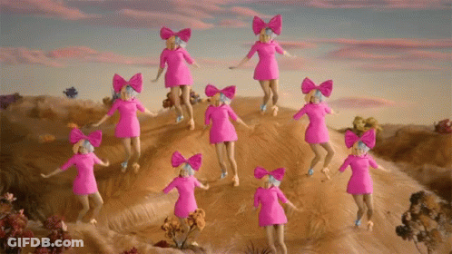 A Group Of Pink Dolls With Bows On Their Heads Are Dancing On A Hill GIF