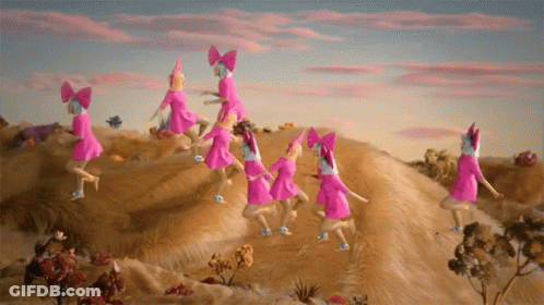 A Group Of Pink Dolls With Bows On Their Heads Are Dancing On Top Of A Hill GIF