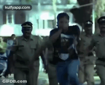 A Group Of Police Officers Are Carrying A Man Down A Street In A Blurry Photo . GIF