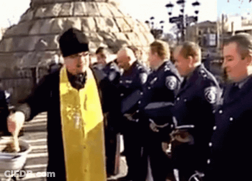 A Group Of Police Officers Are Gathered Around A Priest GIF