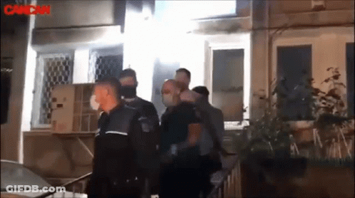 A Group Of Police Officers Are Standing Outside Of A Building With The Word Cancan In The Corner GIF