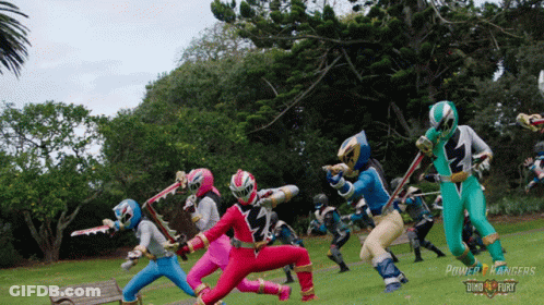 A Group Of Power Rangers In A Park GIF