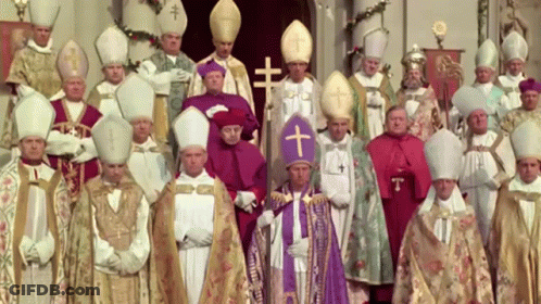 A Group Of Priests Are Posing For A Picture With A Cross On Their Hats GIF