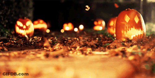 A Group Of Pumpkins With Faces Carved Into Them Are Lit Up In The Dark GIF