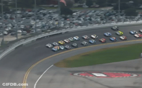 A Group Of Race Cars Are Lined Up On A Race Track GIF