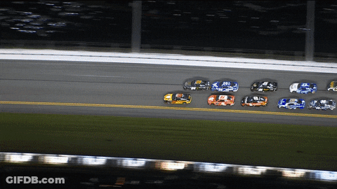 A Group Of Race Cars Are Racing On A Track And One Of Them Has The Number 9 On It GIF