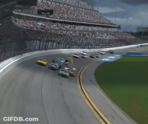 A Group Of Race Cars Are Racing On A Track With The Letter B On It GIF