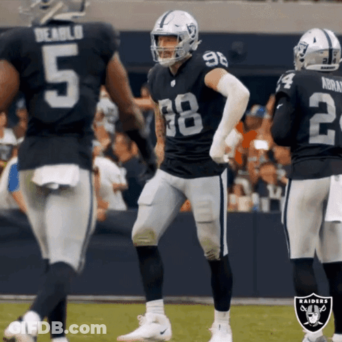 A Group Of Raiders Football Players Are Standing On A Field GIF