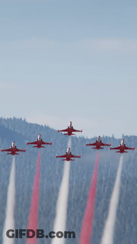 A Group Of Red Jets Flying In Formation With Smoke Trails GIF