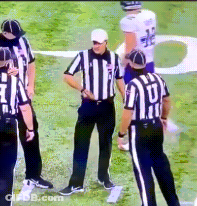 A Group Of Referees Standing On A Field With One Wearing A Jersey That Says ' U ' On It GIF