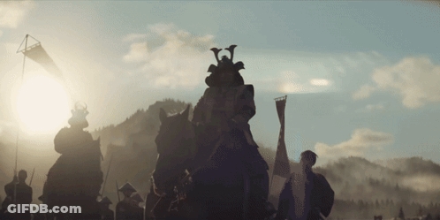 A Group Of Samurai Riding Horses With A Flag In The Background GIF