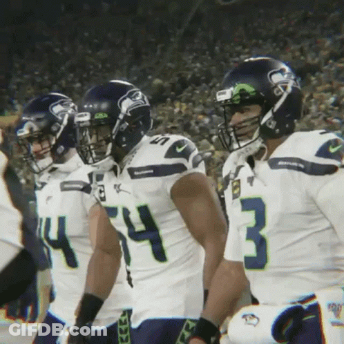 A Group Of Seahawks Football Players Standing In A Line GIF