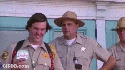 A Group Of Sheriffs Are Standing In Front Of A Building . GIF