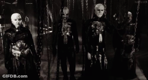 A Group Of Skeletons Are Standing Next To Each Other In A Dark Room . GIF