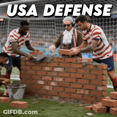 A Group Of Soccer Players Are Building A Wall With Bricks And The Words Usa Defense Above Them GIF