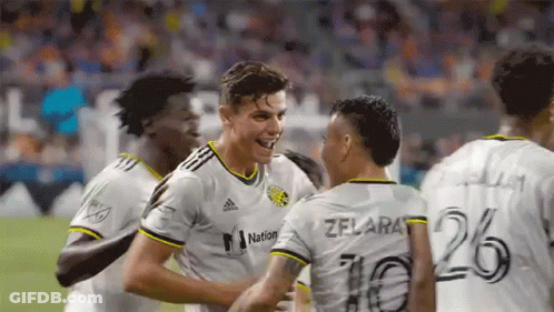 A Group Of Soccer Players Are Celebrating A Goal On A Field . GIF