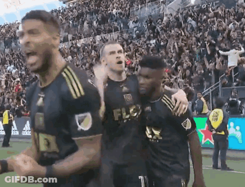 A Group Of Soccer Players Are Celebrating A Goal On A Field . GIF