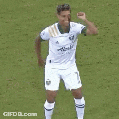 A Group Of Soccer Players Are Celebrating A Goal On A Soccer Field . GIF