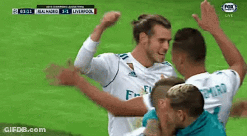 A Group Of Soccer Players Are Celebrating A Goal Together On A Field . GIF