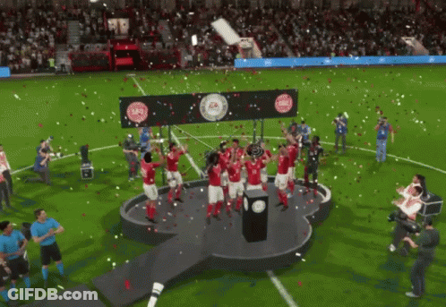 A Group Of Soccer Players Are Celebrating On A Stage With A Trophy GIF