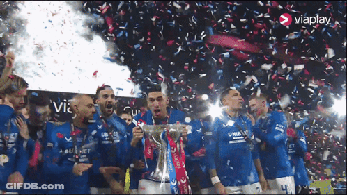 A Group Of Soccer Players Are Celebrating With A Trophy And Confetti With The Word Viaplay In The Corner GIF