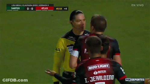 A Group Of Soccer Players Are Gathered Around A Referee Wearing A Bud Light Jersey GIF