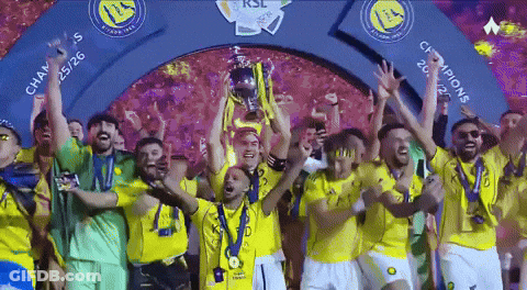A Group Of Soccer Players Are Holding Up A Trophy Under A Sign That Says Champions GIF